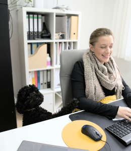 Bild: Carina Schmiedseder im Büro mit ihrem Bürohund Suki