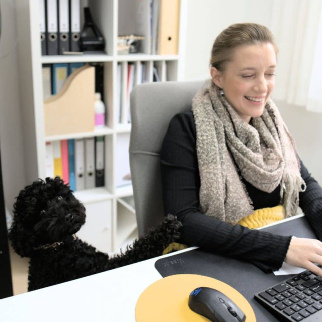 Bild: Carina Schmiedseder im Büro mit ihrem Bürohund Suki